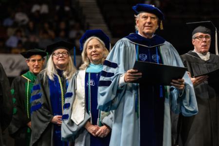 Faculty members lined up on stage at EVMS Commencement 2022