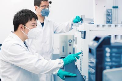 Asian scientist pushing buttons on a machine