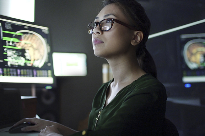 A neurologist studies brain scans on a computer.