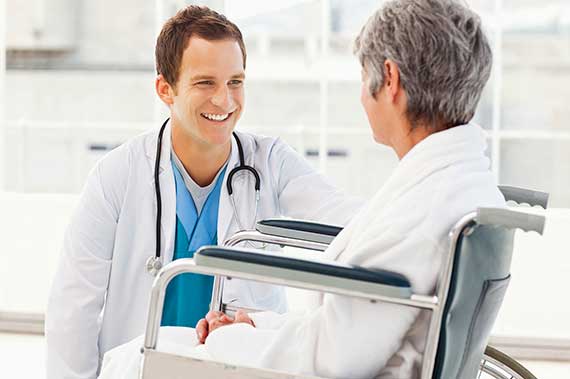 A resident talks with a patient.